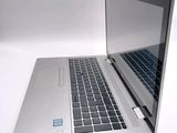 a silver laptop computer sitting on a white surface