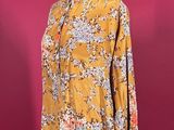 a woman ' s blouse on a mannequin stand against a pink background