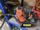 an orange and black chainsaw sitting on top of a shelf next to a red bucket
