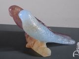 a glass bird sitting on top of a black box