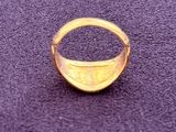 a close up of a gold ring on a purple surface