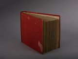 a red book that is open on a gray surface