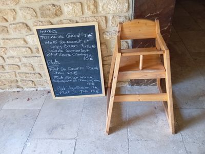 a wooden chair next to a chalk board with writing on it