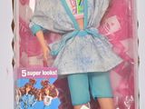 poupée dans la boîte d'une poupée Barbie, vêtue d'un haut bleu et d'un pantalon vert