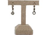 a close up of a pair of earrings on a display stand