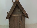 a small wooden birdhouse with two birds on top of it