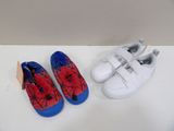Deux paires de chaussures d'enfants sont posées sur une table.