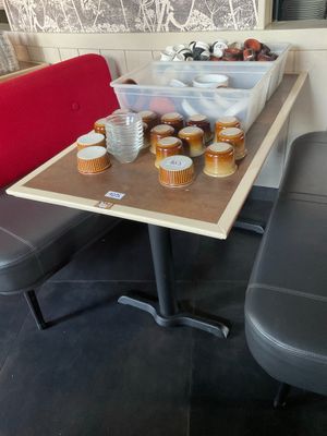 une table sur laquelle sont posées des tasses de café, à côté d'un banc