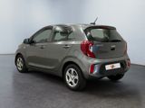 the back of a small grey car is parked in a room