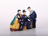 a figurine of three people sitting on a bench