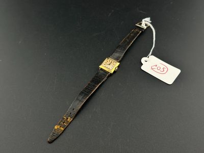 un gros plan d'une montre posée sur une surface noire, avec une étiquette de prix