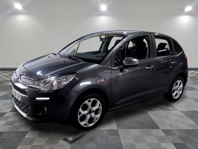 the small car is parked in a large room with a checkered floor