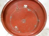 une assiette rouge contenant un dé, posée sur une table blanche