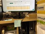 a computer monitor sitting on a desk in a cubicle