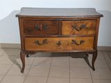 a wooden dresser with a marble top on a tiled floor