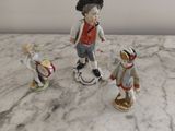 trois figurines représentant un garçon et une fille posées sur une table en marbre