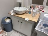 a sink and a trash can in a small bathroom