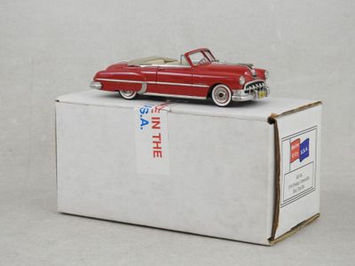 une petite voiture rouge posée sur une boîte