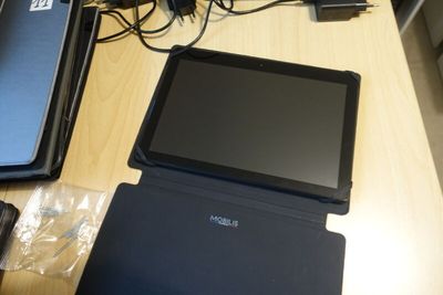 a laptop and a tablet on a table with other electronics