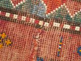 a close up of a colorful rug with a cat on it