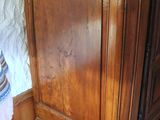 a wooden armoire with a clock on top of it