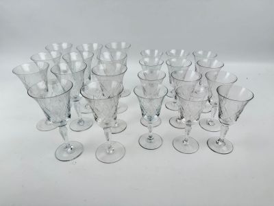 douze verres à vin transparents sont alignés sur une surface blanche