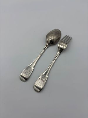 two forks and spoons sitting on a table with a white background