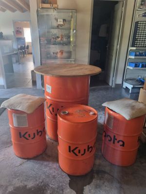 Plusieurs fûts orange sont empilés les uns sur les autres dans un garage