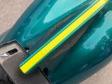 a green motorcycle with a yellow stripe on the side