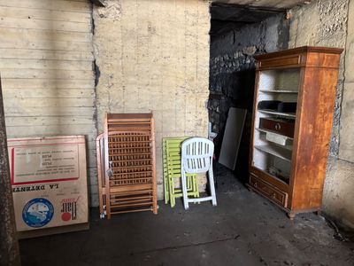 several chairs and a cabinet in the corner of a room