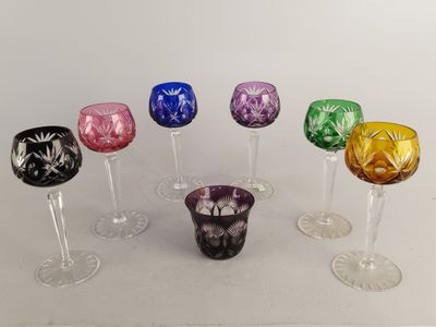 plusieurs verres à vin de différentes couleurs posés sur une table blanche