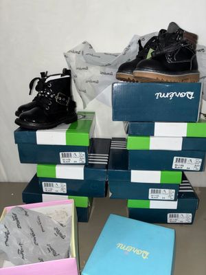 several pairs of shoes are stacked on top of boxes on a table