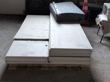 a stack of white boards sitting on a pallet in a room
