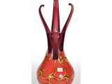 un vase rouge orné d'un motif en spirale doré