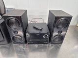 three speakers and a remote sitting on a table