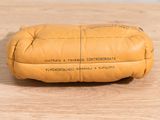 a yellow pillow that is sitting on a wooden table