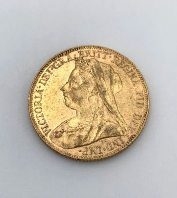 gros plan d'une pièce d'or sur une surface blanche