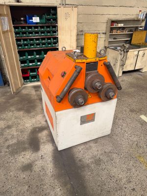 an orange and white machine sitting in a garage next to a pile of boxes