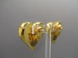 two gold ear plugs that are on a clear stand