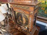 une horloge posée sur une table devant un tableau