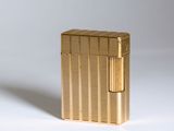 l'image d'un briquet doré posé sur une surface blanche