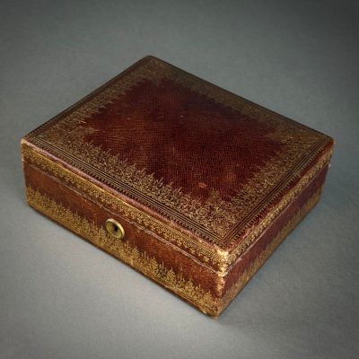a brown leather box with a gold design on it