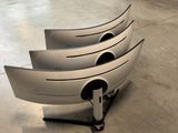 four boats that are sitting on a stand on the floor