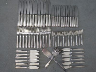 beaucoup de fourchettes et de couteaux disposés sur une table
