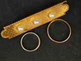 deux alliances en or et une bague en perle sur fond noir