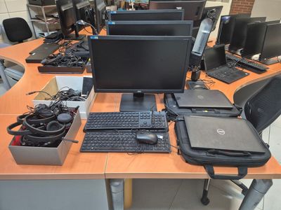 a lot of computer equipment on the desk in this room
