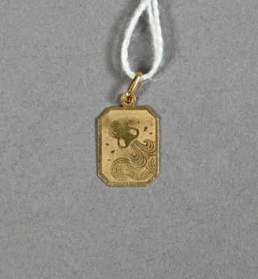 un gros plan d'un pendentif plaqué or orné d'un dragon
