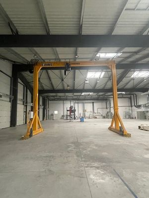 une grande grue jaune dans un vaste entrepôt