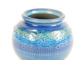 a blue vase that is sitting on a white surface