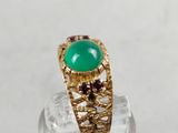 an image of a gold ring with a green stone on it